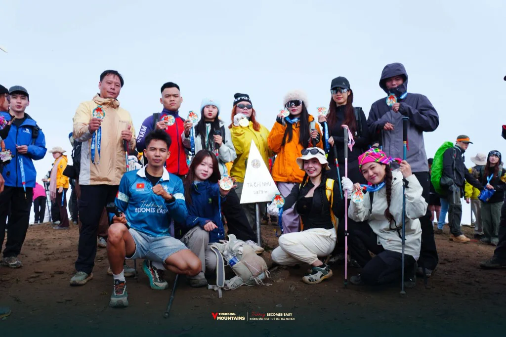 Đoàn VMountains giơ huy chương Finisher bên cột mốc đỉnh Tà Chì Nhù 2979m