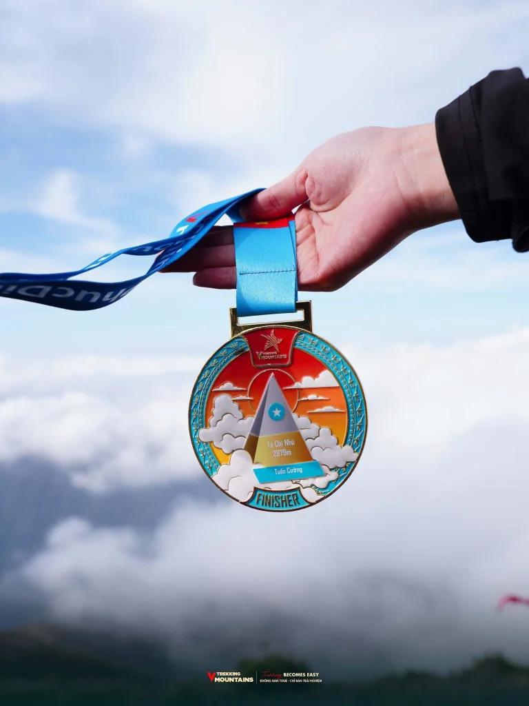 Tay cầm huy chương Finisher VMountains Tà Chì Nhù 2979m trên nền biển mây