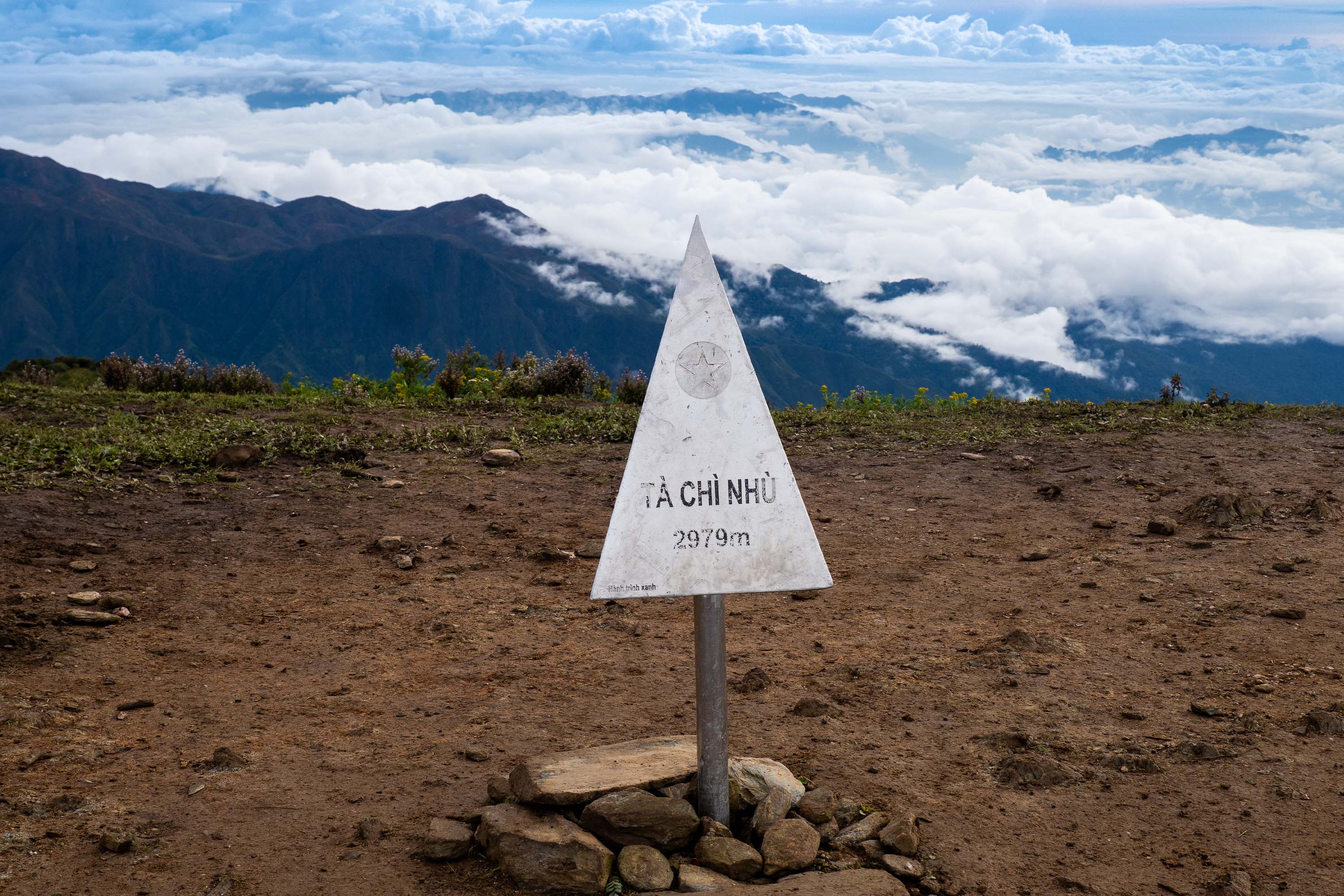 Cột mốc Tà Chì Nhù 2979m trên sống núi, phía sau là biển mây Tây Bắc